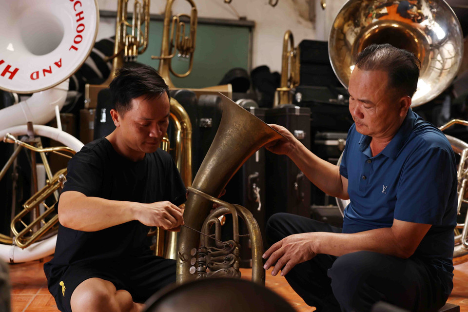 Nguyên Van Huong, de l'Association des trompettistes de Trai Day, commune de Hai Minh (Hai Hâu) et son fils réparent un trombone. Photo : VNA