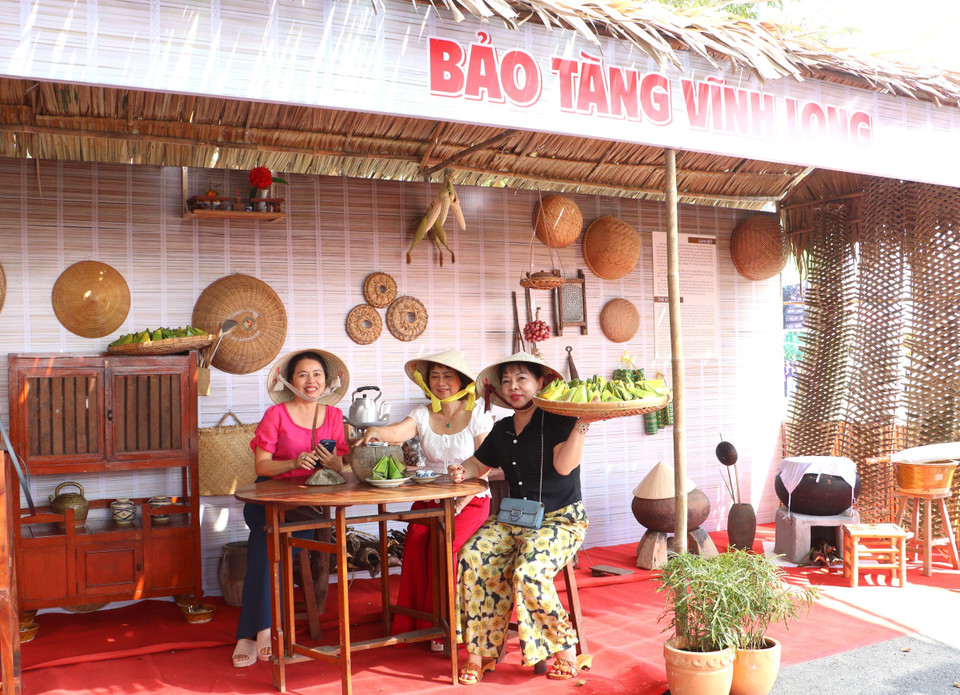 Des touristes prennent des photos dans l’espace « Cuisine traditionnelle », illustrant la vie quotidienne des habitants du Sud du Vietnam. Photo : VNA