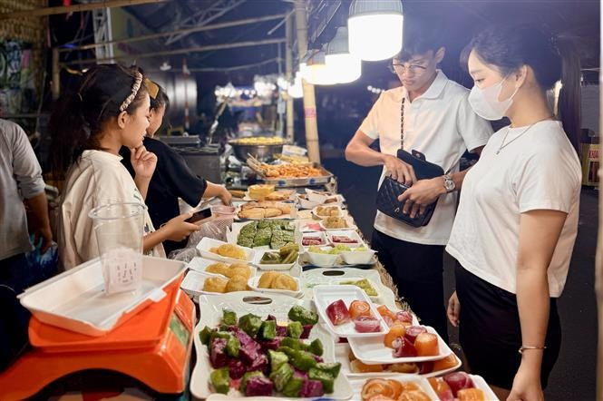 Des visiteurs visitent les stands lors de la Fête des gâteaux traditionnels du Sud - An Giang. Photo : VNA