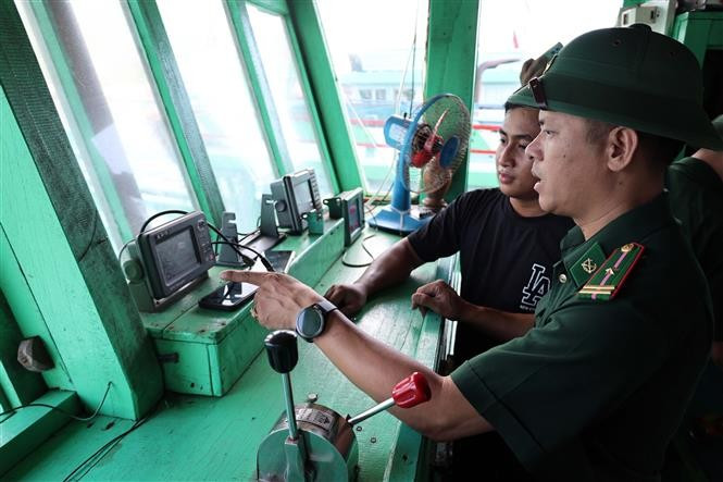 Des officiers et soldats du poste de garde-frontière de Son Tra (Commandement de la Garde-frontière de la ville de Da Nang) vérifient les équipements de communication à bord d’un bateau de pêche. Photo : VNA