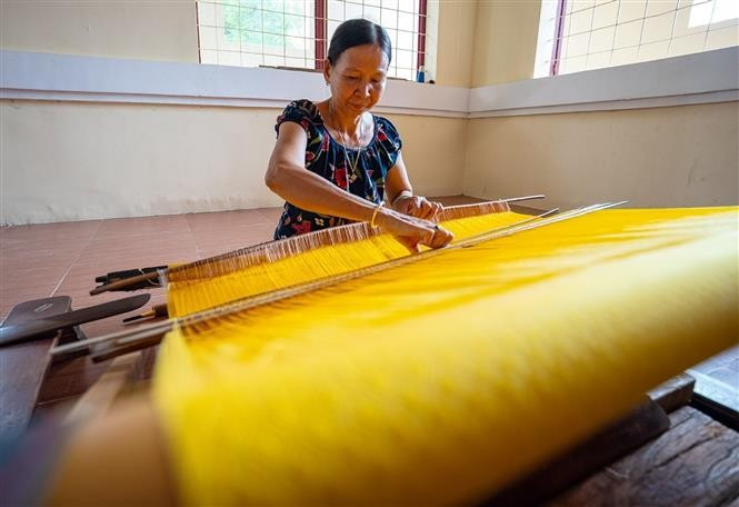 Pour créer de beaux produits, les artisans qualifiés doivent faire preuve de concentration et de persévérance. Photo : VNA
