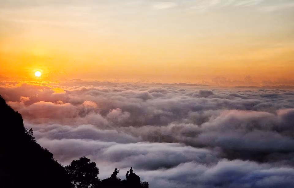 Le paysage se pare de nuances de rose éclatantes avant de s’illuminer d’une lumière vive, révélant montagnes, prairies verdoyantes et une mer de nuages infinie.