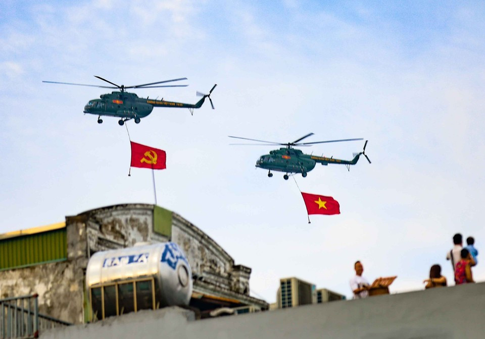 Des hélicoptères Mi-171, Mi-17 et Mi-8 portant les drapeaux du Parti et de l'État survolent la place Ba Dinh. Photo : Lam Khanh - VNA