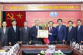 Le secrétaire général du Parti, Tô Lâm (4e à gauche) remet l'Insigne des 45 ans d'adhésion au Parti à Phan Dinh Trac. Photo : VNA