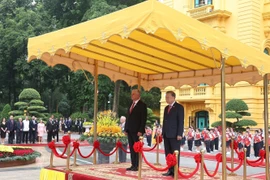 Le Secrétaire général To Lam et le Premier secrétaire et président cubain Miguel Díaz-Canel Bermúdez à la tribune, écoutant la fanfare militaire jouer les hymnes nationaux des deux pays. Photo : VNA