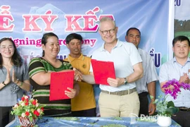 Mme Thi Khui, cheffe de la coopérative agricole d’anacarde biologique de Trang Co – Bu Lach, signe un accord de coopération pour l'achat de noix de cajou avec un représentant de la sarl Intersnack Vietnam. Photo : Journal Dong Nai