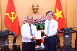 Doan Minh Huan (droite), directeur de l’Académie nationale de politique Ho Chi Minh, offre des livres à Leeber Leebouapao, président de l’Institut national des sciences économiques et sociales du Laos . Photo : VNA