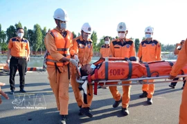 Ramener à terre le marin malade. Photo : VNA