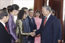 Le secrétaire général To Lam rencontre la communauté vietnamienne au Laos. Photo : VNA