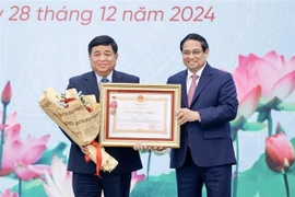 Le Premier ministre Pham Minh Chinh (droite) a décerné l'Ordre du Travail de première classe au ministre du Plan et de l'Investissement Nguyen Chi Dung. Photo : VNA