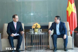 Le Premier ministre Pham Minh Chinh (droite) travaille avec le dirigeant de la Société à responsabilité limitée Hyosung Vina. Photo : VNA