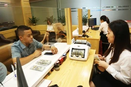Des clients effectuent des transactions à la Banque pour l'agriculture et le développement rural (Agribank). Photo : Hanoimoi