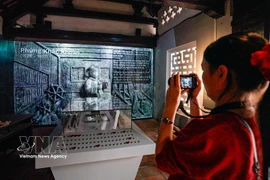 Des visiteurs découvrent l'exposition « Histoire de la pierre », qui mêle techniques traditionnelles et numériques. Photo : VNA
