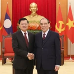 L’ancien secrétaire général du Parti Nong Duc Manh (droite) et le dirigeant lao Thongloun Sisoulith. Photo: VNA