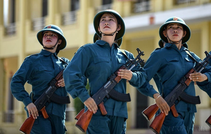 Malgré le soleil brûlant, les miliciennes du Nord-Ouest s'entraînent avec enthousiasme pour préparer le meilleur défilé militaire au service du 70e anniversaire de la victoire de Diên Biên Phu. Photo: VNA