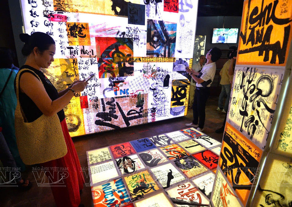 Les visiteurs admirent les œuvres de calligraphie vietnamienne.