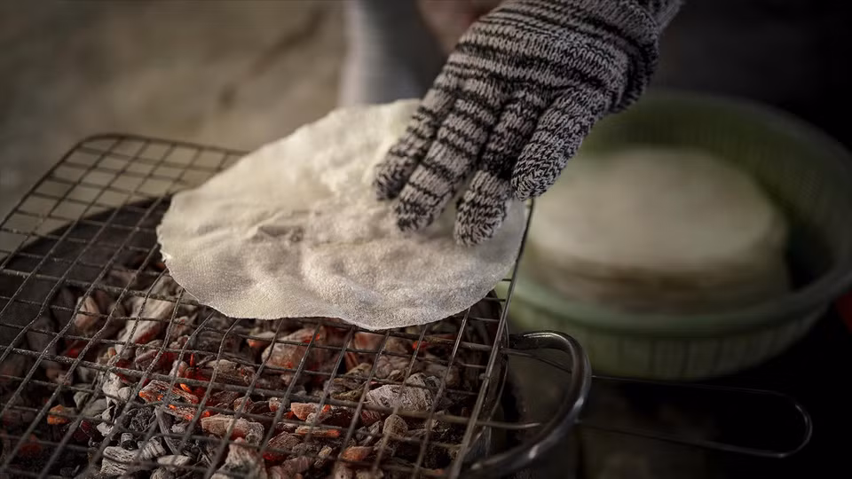 Pour manger, on tape sur le "banh dap" pour le briser en petits morceaux. Vous utilisez ensuite ces morceaux pour ramasser les palourdes sautées et les déguster. La fraîcheur des palourdes, l'arôme irrésistible des oignons frits, du poivre, de la coriandre vietnamienne et la touche piquante du piment créent un souvenir culinaire inoubliable. Photo : Vietnam Illustré