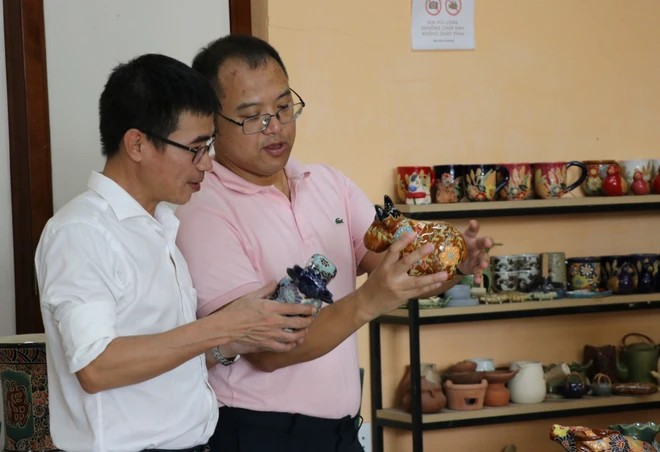 Des amateurs découvrent la céramique de Bien Hoa. Photo : VNA