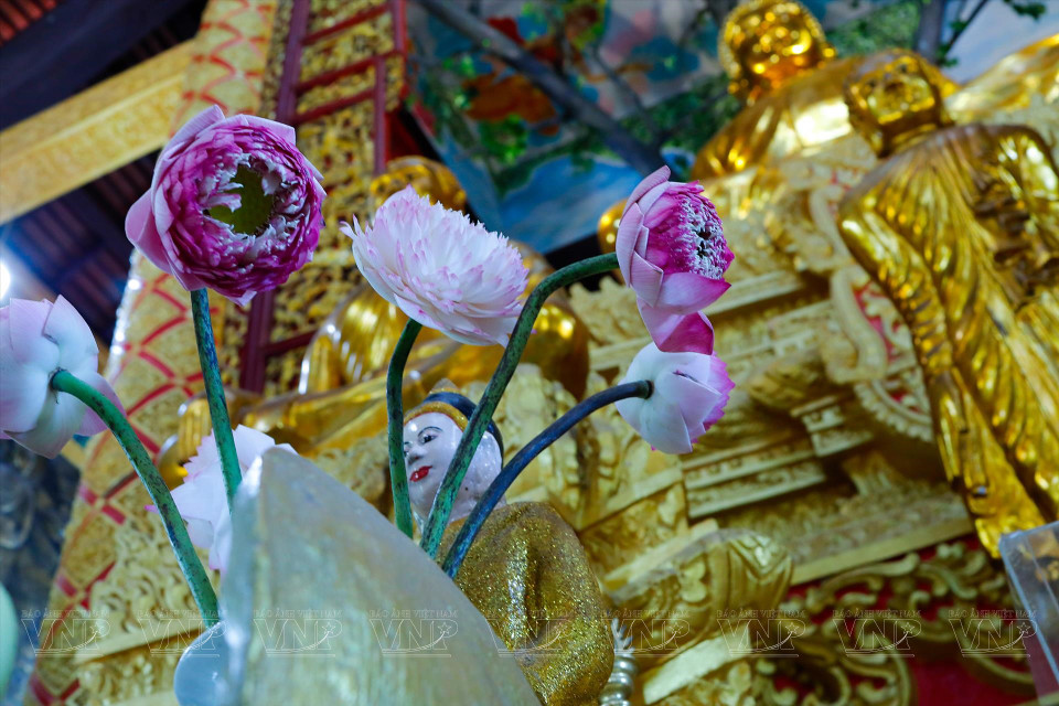 Les gens offrent des fleurs à Bouddha lors de la cérémonie de requiem. Photo: Vietnam Illustré