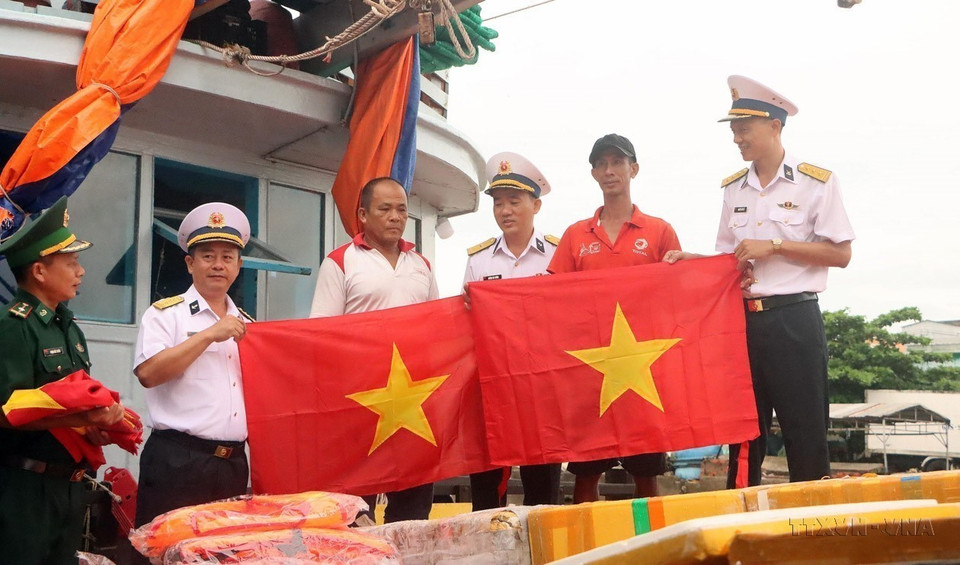 Le commandement de la région navale 2 de la Marine populaire vietnamienne offre des drapeaux nationaux à des pêcheurs de Soc Trang. Photo: VNA
