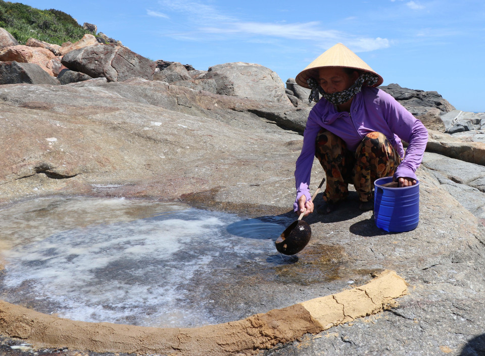 Une paludière du village de Co ajoute de l'eau de mer pour augmenter l'épaisseur du sel. Photo: VNA