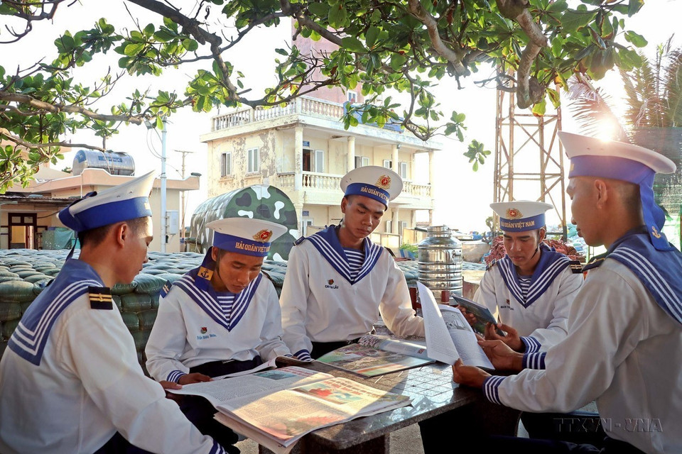 Les soldats de l'île d'An Bang s'informent et se cultivent dans des livres et journaux après leur journée de travail. Photo : VNA