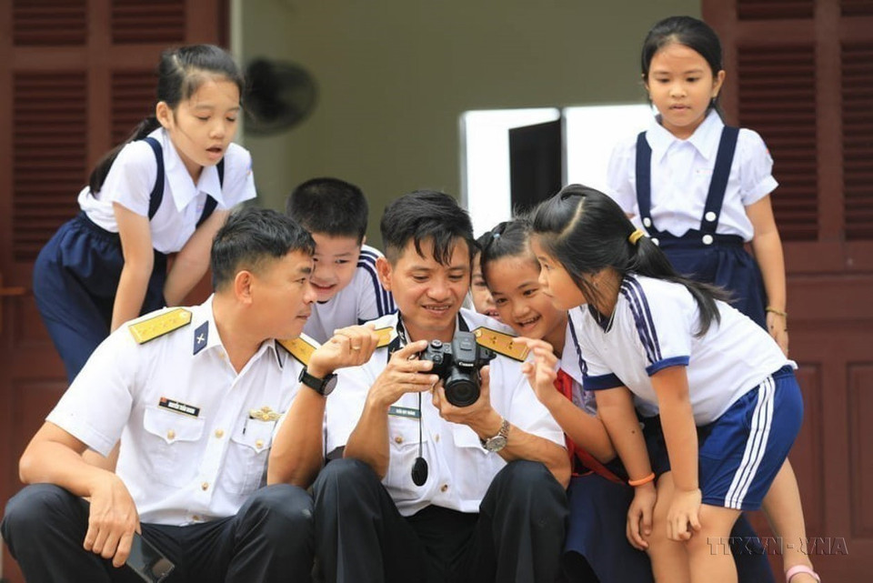 Des officiers de la région navale 4 et des élèves sur l'île de Sinh Ton. Photo : VNA