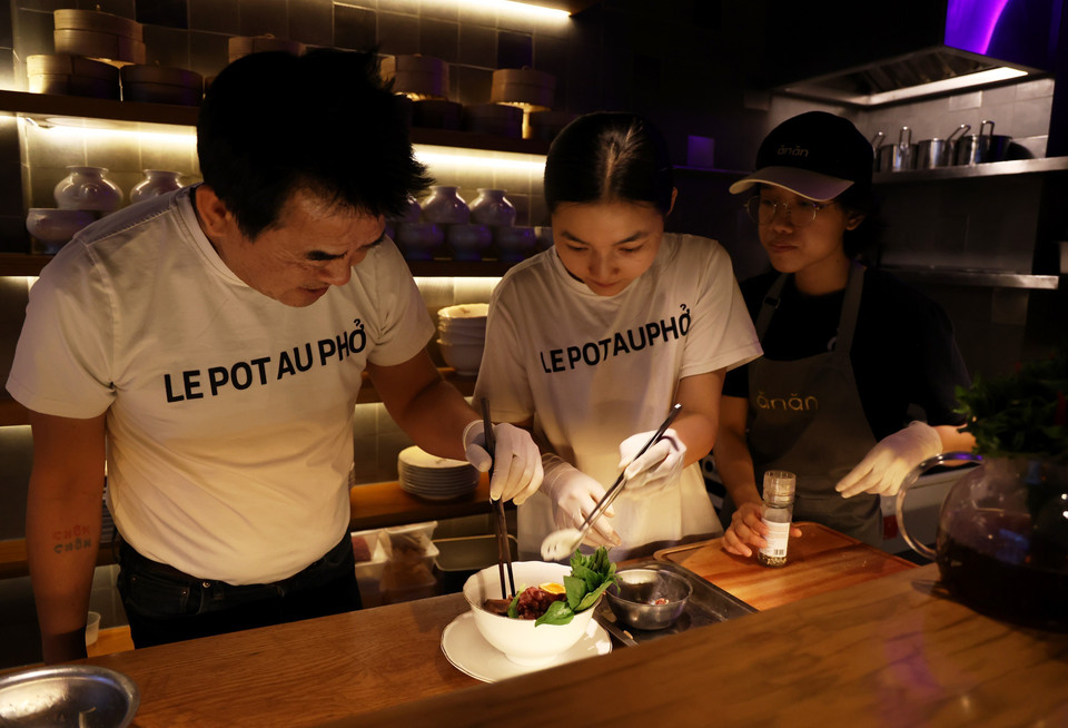 Les chefs de cuisine du Pot Au Pho préparent un bol spécial de pho pour les convives. Photo : VNA