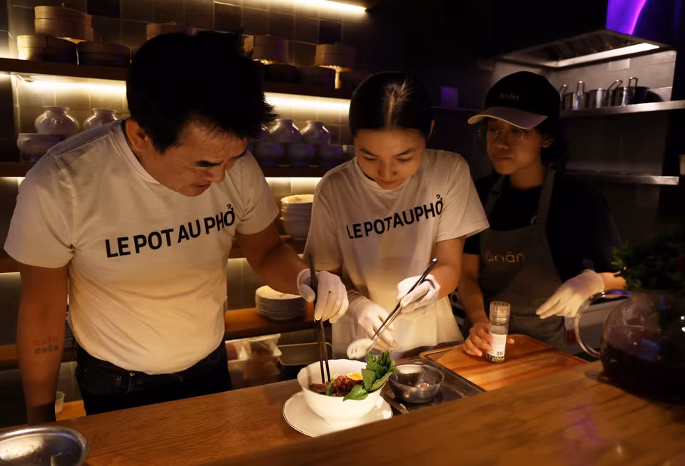 Les chefs de cuisine du Pot Au Pho préparent un bol spécial de pho pour les convives. Photo : VNA