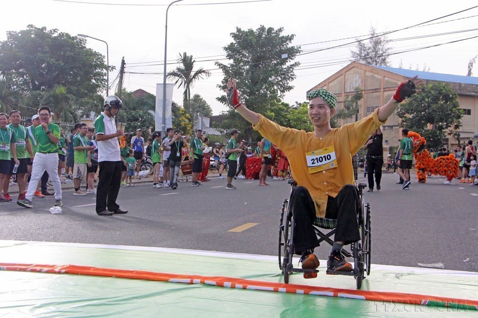 Un athlète handicapé franchit la ligne d'arrivée d'un 500 mètres lors d'une compétition caritative en 2024. Photo : VNA