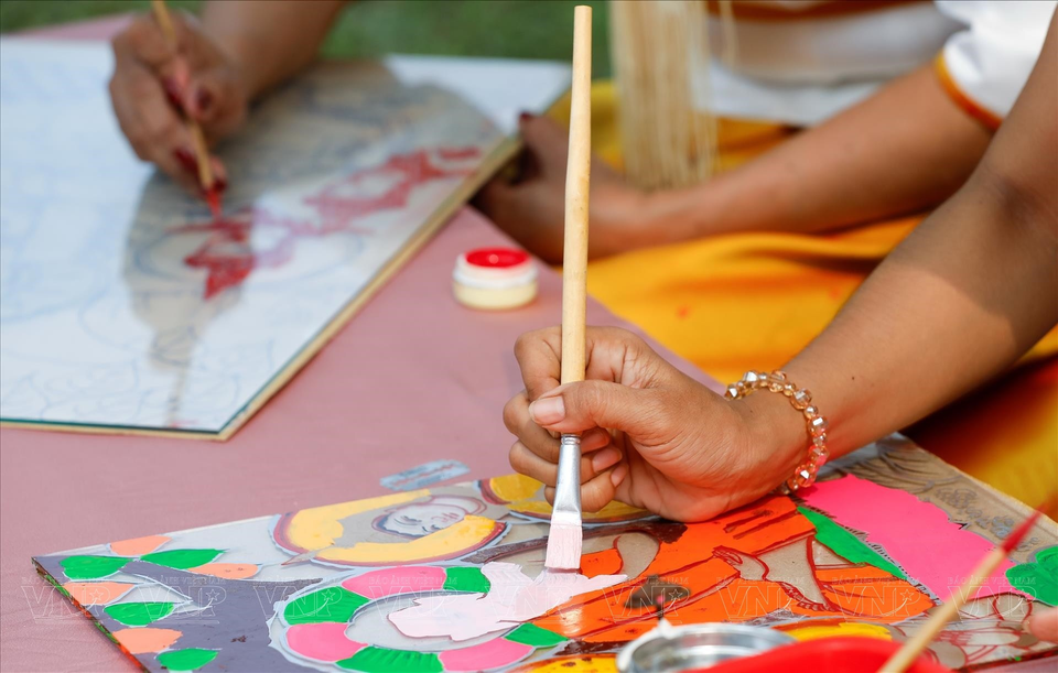 La peinture sur verre est différente de la peinture sur d'autres matériaux dans la mesure où vous devez dessiner le motif en premier plutôt qu'en dernier. La peinture sur verre consiste à exécuter le travail de peinture au revers d'une plaque de verre. L’une des difficultés du procédé est de peindre le motif inversé, puis d'exécuter les détails avant le fond; le spectateur doit regarder l'œuvre terminée sur le côté non peint de la plaque de verre. Photo : Vietnam Illustré