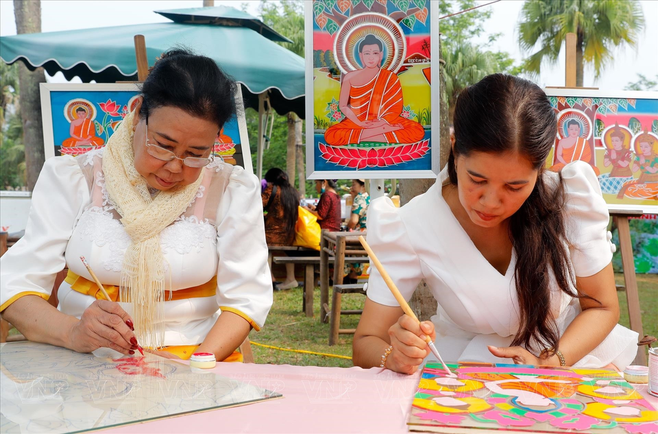 Huynh Thi Soc Kha et sa mère réalisent une peinture sur verre inversé. Photo : Vietnam Illustré
