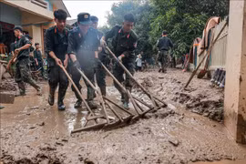 Des policiers aides des habitants de la commune de Phuc Khanh, district de Bao Yen, province de Lao Cai, à nettoyer leurs maisons après le typhon Yagi. Photo: VNA