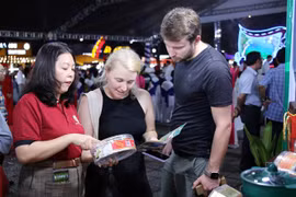 Des touristes se renseignent sur des produits de nids de salanganes de la province de Ninh Thuan lors de l'événement. Photo : VNA