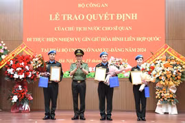 Le ministre de la Sécurité Publique, Luong Tam Quang, remet la décision du président à trois officiers. Photo: bocongan.gov.vn