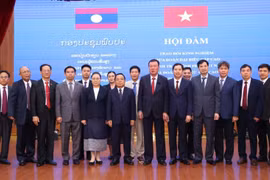 L'inspecteur général du gouvernement vietnamien Doan Hong Phong et son homologue lao Khamphan Phommaphat prennent une photo avec les inspecteurs de deux pays. Photo: VNA