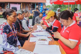 Le comité d'organisation aide des habitants de l'ethnie Co Tu à enregistrer des cartes SIM. Photo: VNA