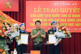 Le vice-ministre de la Sécurité publique Luong Tam Quang présente la décision du président à deux agents de la Sécurité publique d'effectuer des missions de maintien de la paix des Nations Unies. Photo: VNA