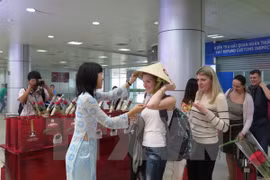 Des touristes russes reçoivent des cadeaux à l'aéroport de Cam Ranh, province de Khanh Hoa. (Photo: Tiên Minh/VNA)