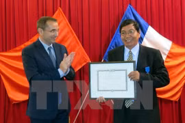 M. Jean-Noël Poirier, ambassadeur de France au Vietnam, remet l'insigne de l'Ordre national du Mérite à M. Nguyen Van Me. (Source : VNA)