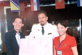 Des responsables du Comité provincial populaire de Quang Ninh offre un cadeau au capitaine du navire de croisière SuperStar Virgo. Photo : VNA