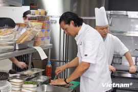 Le chef cuisinier Bobby Chinn (premier plan) prépare et propose aux invités de l’hôtel Movenpick Heritage Hotel Sentosa à Singapour certaines spécialités du Vietnam. (Source : VNA)