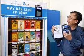 Le directeur de la compagnie des livres électroniques Tre (Ybook), Dông Phuoc Vinh, à côté d'un distributeur automatique de livres. 