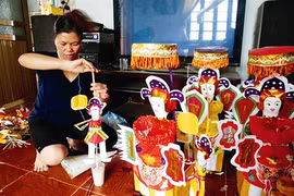Nguyên Thi Tuyên en plein travail de fabrication de jouets traditionnels pour la Fête de la mi-automne. Photo : VNP/VNA