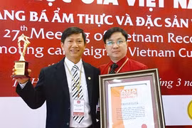 Le médecin Phùng Tuân Giang (droite) reçoit le certificat de «Médecin qui a soigné beaucoup de malades de divers pays par la médecine traditionnelle du Vietnam».