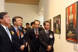 Le directeur général de l'Agence vietnamienne d'Information, Nguyen Duc Loi et les délégués visitent une exposition photographe. (Source: YONHAP/AVI)