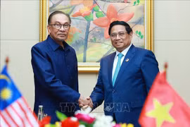 Le Premier ministre Pham Minh Chinh (à droite) et son homologue malaisien Anwar Ibrahim, à Vientiane, le 10 octobre. Photo: VNA