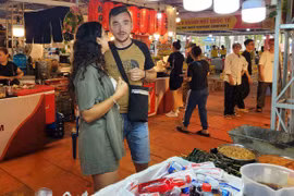 Maria et son petit ami cherchent des plats vietnamiens lors du festival le soir du 23 octobre. Photo: CPV