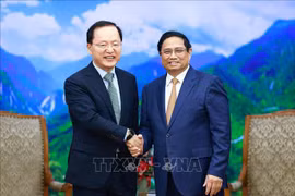 Le Premier ministre Pham Minh Chinh (à droite) serre la main du directeur financier de Samsung Electronics Park Hark-kyu, à Hanoi, le 9 mai. Photo: VNA