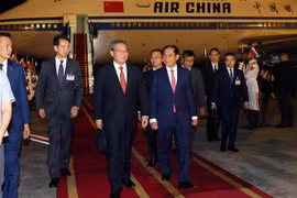 Le Premier ministre chinois Li Qiang (au centre) accueilli à sa descente à l’aéroport international de Nôi Bài, à Hanoi. Photo : VNA